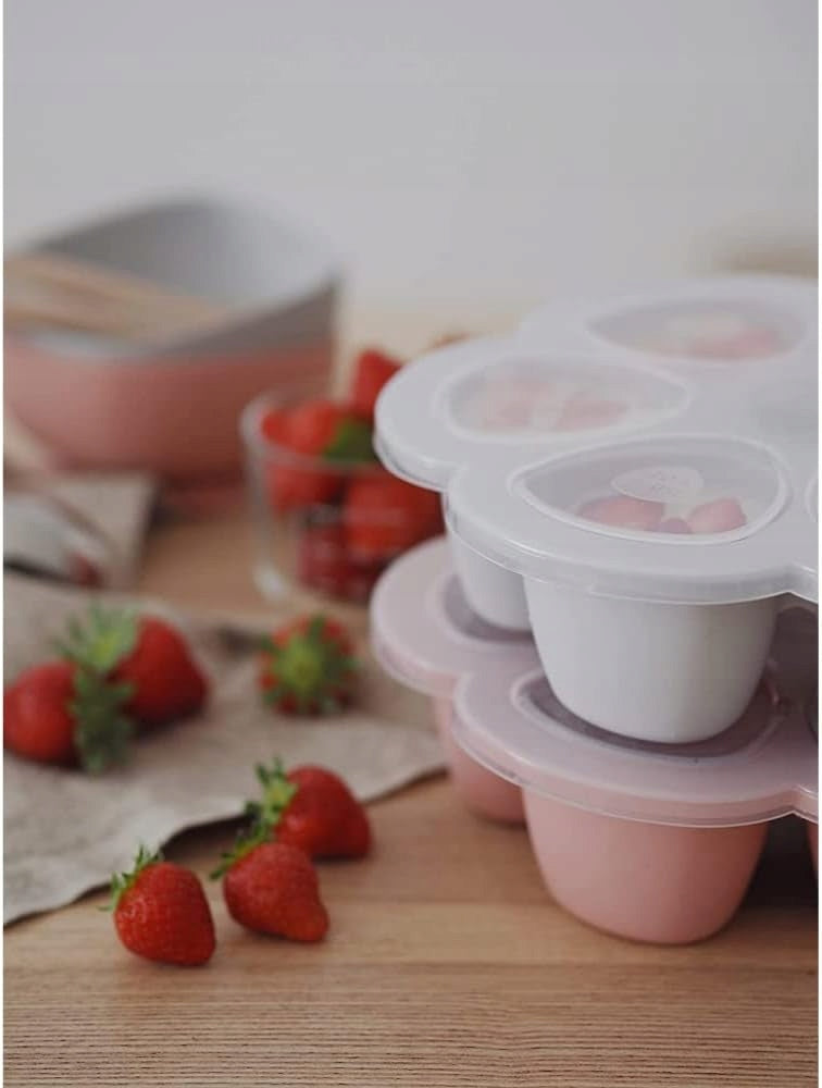 Poglądowe zdjęcie: różowa i szara foremka z przezroczystymi pokrywkami obok truskawek.