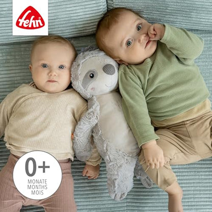 Dwoje dzieci leżących na macie z szarym leniwcem FEHN XL między nimi.