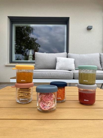 Zdjęcie poglądowe Béaba Glass Portions Sunrise – pojemniki z żywnością ustawione na stole