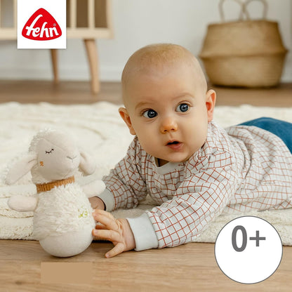Beżowa owca FEHN obok dziecka leżącego na brzuchu na macie.